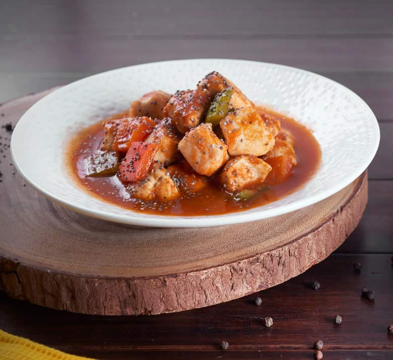 Pollo agridulce servido en plato blanco Pollo agridulce servido en plato blanco