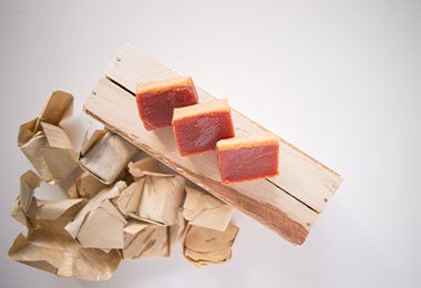 Dulce de guayaba en hojas de bijao en fondo blanco.