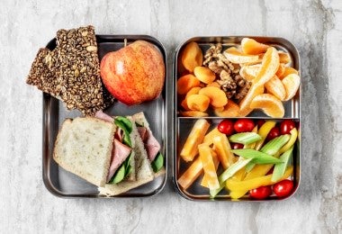 Lonchera con sandwich, semillas y frutas para alimentación escolar completa
