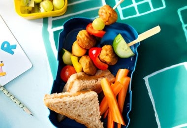 Lonchera para alimentación escolar con sándwich integral, brochetas de pollo y frutas