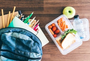 Lonchera escolar con sándwich, zanahorias y agua para alimentación equilibrada