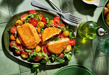Ensalada balanceada con croqueta de queso y tomates frescos para cenar
