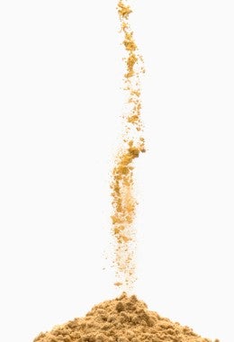 Polvo marrón vertiéndose en una pila.