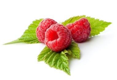 Frambuesas frescas sobre hojas, ingrediente clave para elaborar té de hojas de frambuesa