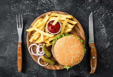 Hamburguesa de ternera, patatas fritas, pepinillos, cebolla y ketchup.