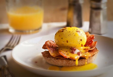 Huevos Benedict. Huevo pasado por agua con tocino y salsa holandesa sobre un muffin inglés.