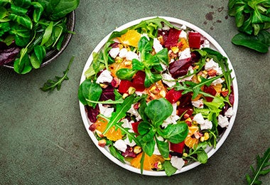 Ensalada vibrante con espinacas, naranja, remolacha y queso feta, que muestra una forma creativa de entender para qué sirve la alcachofa en combinaciones frescas