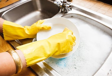Persona lavando adecuadamente sus herramientas de cocina, como el rallador de repollo.