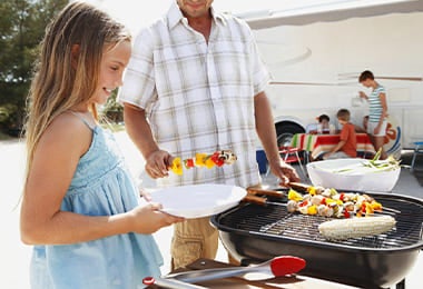 Familia disfrutando de un BBQ en parrilla volcánica durante un viaje.