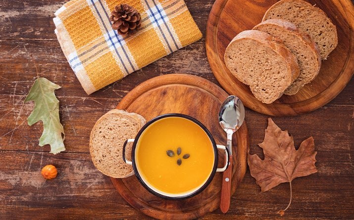 Una de las mejores recetas con zapallo es una crema, acompañada con pan.