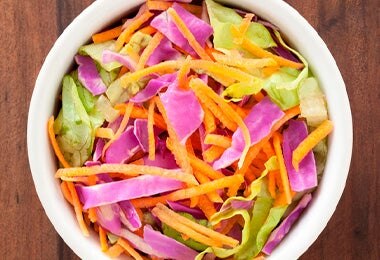 Tazón con zanahoria y col china, los ingredientes de los rollitos primavera originales