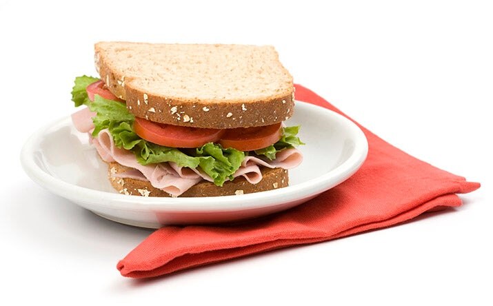 Un sándwich clásico de jamón, lechuga y tomate, uno de los snacks saludables más populares