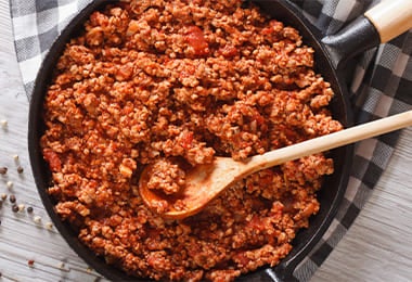 Sartén de hierro fundido lleno de carne molida.