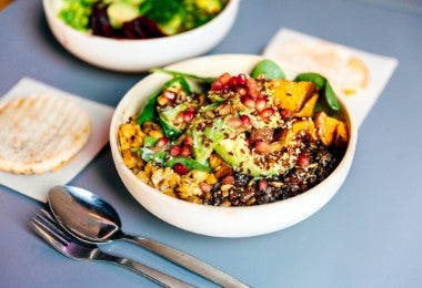 Tazón vegetariano con aguacate, calabaza, lentejas y granada.