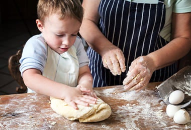 Mujer y niño amasando masa para pan con textura creada con la zaranda.