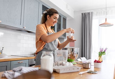 Mujer cocinando con sal artesanal. Mujer cocinando con sal artesanal en la cocina.