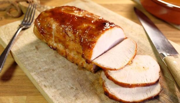 Porchetta rebanada sobre tabla de picar.