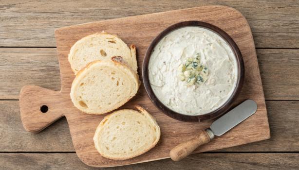 Tabla con rodajas de pan para esparcir salsa gorgonzola