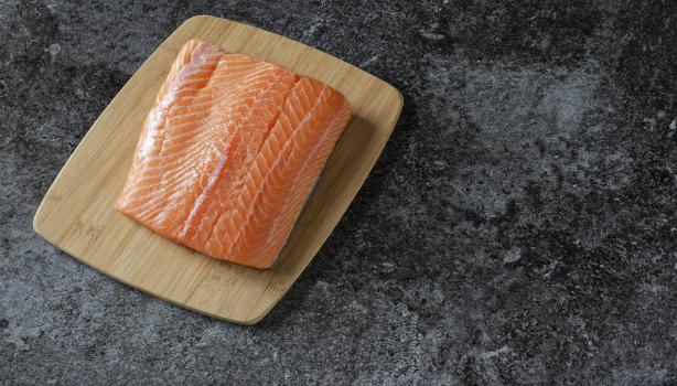 Filete de salmón fresco sobre tabla de madera
