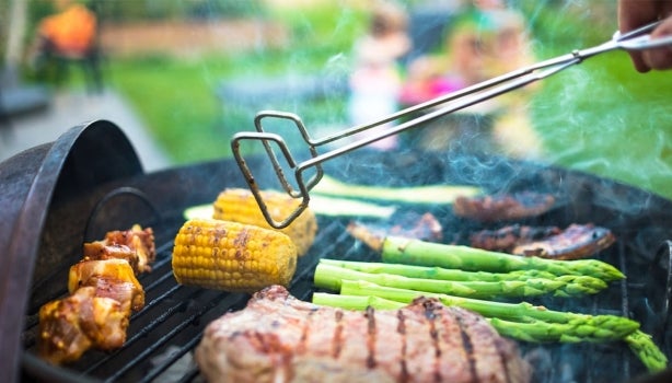 Filete de carne asada con choclo, chorizo y vegetales sobre parrilla volcánica.