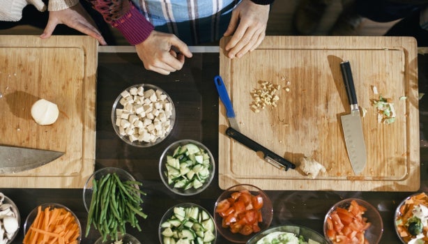 Tabla de cortar de madera con cuencos y verduras, inocuidad que es.
