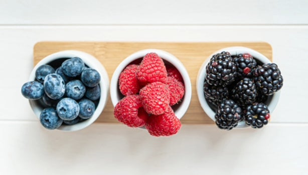 Mezcla de frutos silvestres, frambuesas, arándanos y moras aisladas sobre fondo blanco.