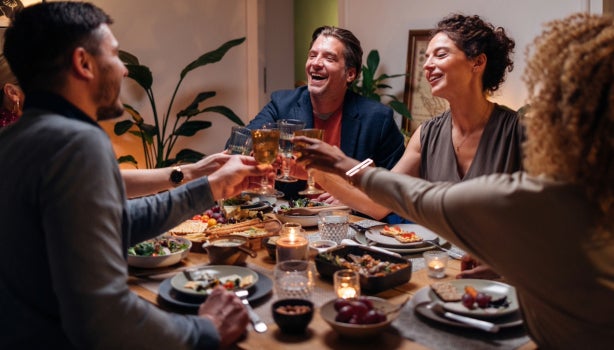 Amigos brindando con una copa de vino durante una cena.