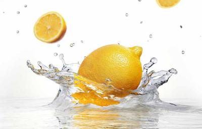 Un tipo de limón amarillo cayendo en el agua