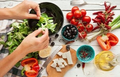 Una persona preparando una ensalada navideña, deliciosa y colorida. 
