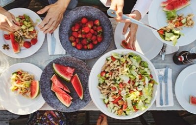 Mesa de picnic con ensalada con pasta y frutas