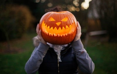 Calabaza de Halloween sobre el cuerpo de una persona.  