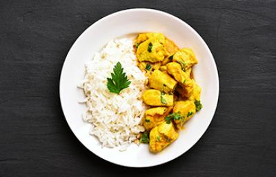 Arroz basmati con pollo al curry y unas hojitas de perejil.