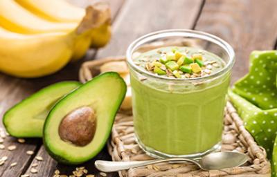 Aguacate partido a la mitad con un batido de cereal y verduras para desintoxicar el cuerpo