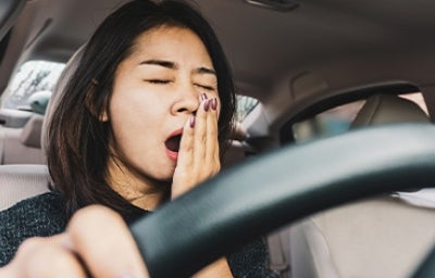 Una mujer bostezando, pensando en cómo dejar de procrastinar