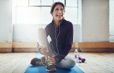 Una mujer preparándose para hacer deportes populares en su casa