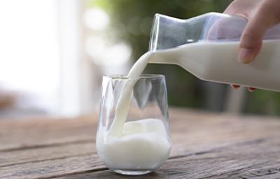 Jarra y vaso con un tipo de leche sobre una mesa de madera