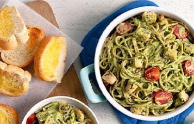 Pasta pesto con tomate cherry y queso, acompañado de pan tostado con mantequilla