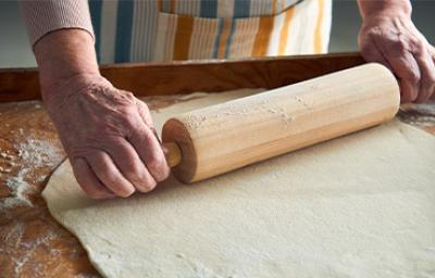 Persona estirando masa con rodillo de cocina Persona estirando masa con rodillo de cocina