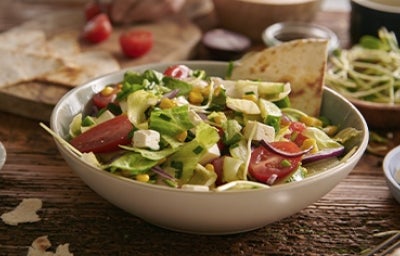 Ensalada mediterránea en una mesa con diferentes acompañamientos