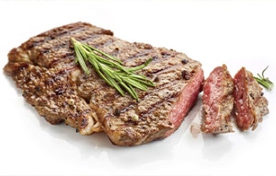 Corte de solomillo cocinado con una receta de hierbas, romero y condimentos sobre un fondo blanco