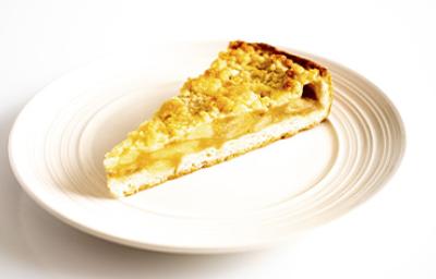 Una porción de tarta de lychees y almendras en un plato blanco