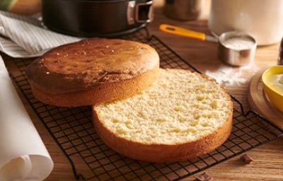 Bizcocho genovés abierto en capas sobre una red metálica negra