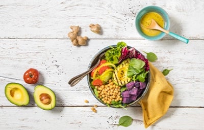 Plato con variedad de verduras y granos, receta de ensalada de aguacate