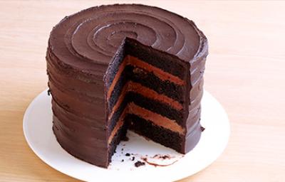 Una Tarta Sacher redonda con su interior descubierto sobre un plato blanco