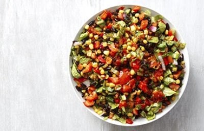 Una ensalada cremosa con maíz, tomate y aguacate en toma cenital