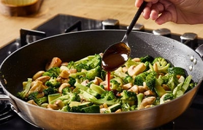 Ensalada de brócoli y hongos aderezada con salsa hoisin en una sartén wok
