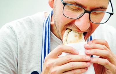 Hombre comiendo empanadas de hojaldre Hombre degustando unas deliciosas empanadas de hojaldre