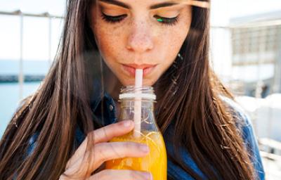 Jugo de zanahoria con limón, refrescante y beneficioso Mujer bebiendo un refrescante jugo de zanahoria con limón