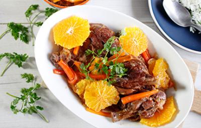 Cerdo con salsa de naranja, rodajas y arroz blanco Plato de cerdo con salsa de naranja, acompañado de rodajas de naranja