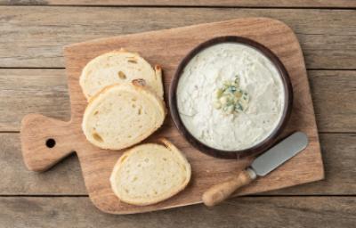 Tabla con rodajas de pan para esparcir salsa gorgonzola Tabla con rodajas de pan para esparcir salsa gorgonzola